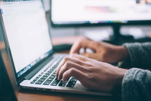 hands typing on computer