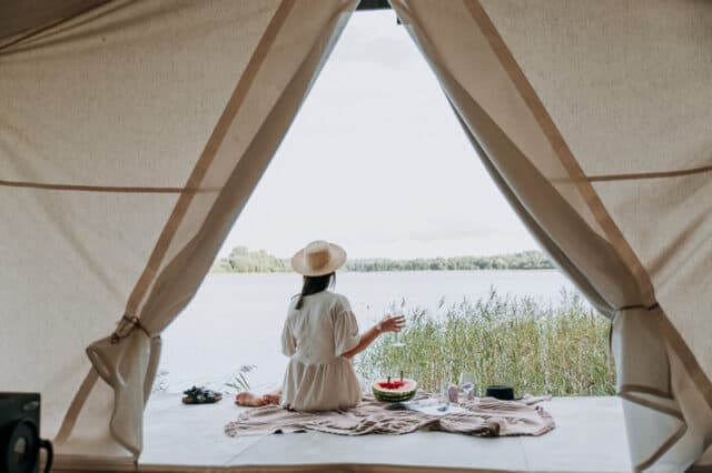 lady in glamping tent drinking wine