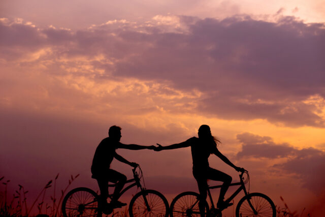 couple biking sunset silhouette