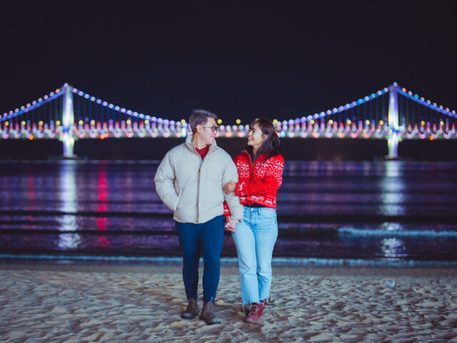 busan beaches couple at night with gwangan bridge in the background