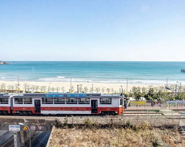 busan beaches songjeong dong with haeundae blueline park beach train passing in front